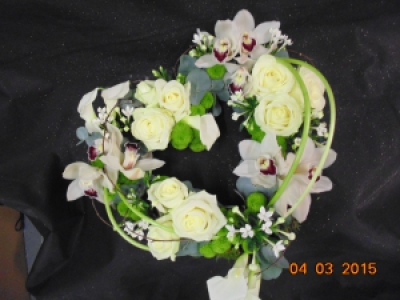 contemporary heart - an open heart wreath adorned with white calla lillies, orchids and roses with eucalyptus foliage and green spray chrysanthemum and white bouvardia
